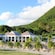 Palm trees and mountainous vegetation surround the colonial exterior of the Fairview Great House and Botanical Garden in Saint Kitts, West Indies